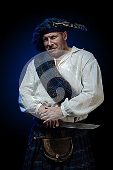 Man with a beard in a blue checkered Scottish costume