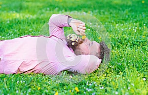 Man with beard on calm face sniffs dandelion. Peace and tranquility concept. Guy with bouquet of daisies in beard