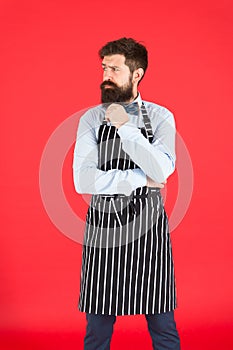 Man with beard cook hipster apron. Hipster chef cook red background. Bearded man chef cooking. Restaurant staff and