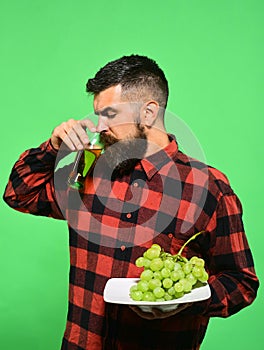 Man with beard drinks glass of grape juice or wine