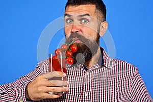 Man with beard drinks tomato juice isolated on white background. Farming and gardening concept. Farmer with surprised