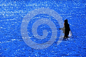 Man with Beard Flyfishing Fly Fishing in River Silhouette with Sunlight