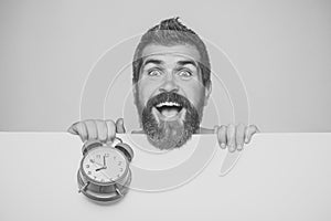 Man with long beard hold alarm clock.