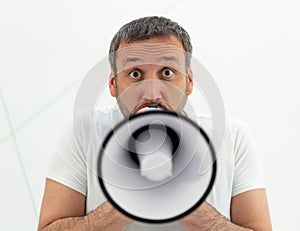 A man with beard holding white megaphone