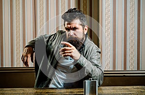 Man with beard holds glass brandy. Man holding a glass of whisky. Handsome stylish bearded man is drinking whiskey