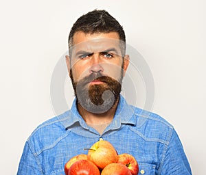 Man with beard holds red apples isolated on white background.