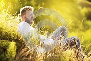 Man with a beard lies on a summer meadow