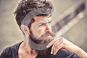 Man with beard and mustache looks thoughtful or troubled Bearded man on concentrated face touches beard. Hipster with