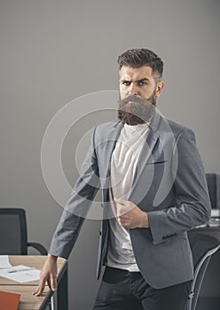 Man with beard and mustache on serious face. Bearded man in casual suit in office. Confident businessman at working