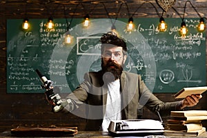 Man with beard and mustache in university. Bearded man with book and retro typewriter. Scientist make research with