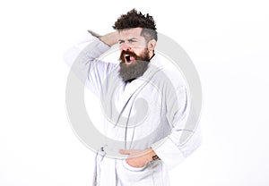 Man with beard and mustache yawning while scratching, itching head, isolated on white background. Guy drowsy with
