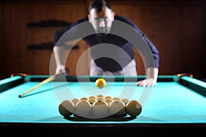 A man with a beard plays a big billiard. Party in a 12-foot pool