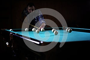 A man with a beard plays a big billiard. Party in a 12-foot pool