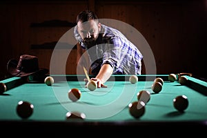 A man with a beard plays a big billiard. Party in a 12-foot pool