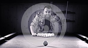 A man with a beard plays a big billiard. Party in a 12-foot pool