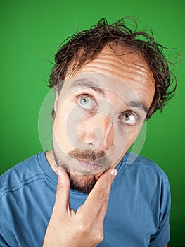 Man with a beard stroking his chin while in deep thoughts