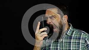 Man with beard talking on the phone screaming and shouting angry and furious