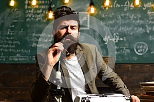 Man with beard on thinking face. Bearded man with retro typewriter and microscope. Scientist make research in university