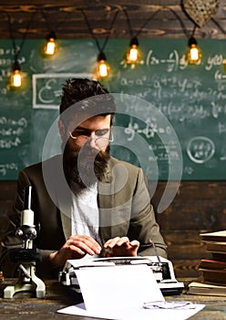 Man with beard typewrite research paper. Bearded man type on vintage typewriter. Businessman in suit work at desk