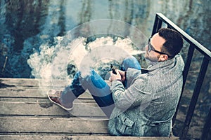 Man with beard vaping outdoor electronic sigarette