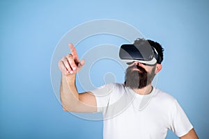 Man with beard in VR glasses, light blue background. Interactive surface concept. Guy with head mounted display interact