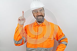 Man with beard wearing worker uniform and hardhat showing pointing up finger number one while smiling onfident happy