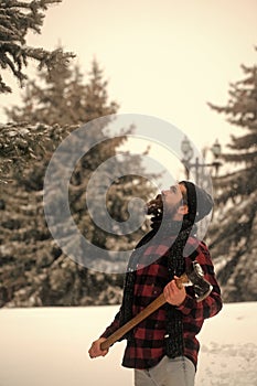 Man with beard in winter forest with snow hold axe.