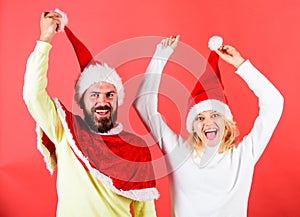 Man with beard and woman in santa hat with pompon red background. Christmas masquerade or karnival concept. Couple