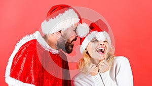 Man with beard and woman santa hat red background. Christmas masquerade karnival concept. Couple cheerful face celebrate