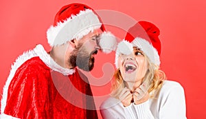 Man with beard and woman santa hat red background. Couple cheerful face celebrate christmas. Rent santa costume. Couple