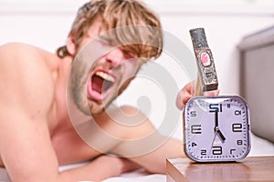 Man bearded annoyed sleepy face lay pillow near alarm clock. Break discipline regime. Stop ringing. Annoying sound