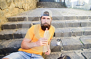 Man bearded enjoy street food urban background. Take break to have snack. Urban food culture concept. Hipster eat hot