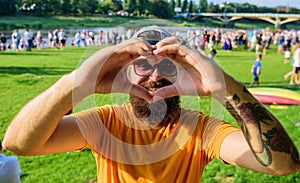 Man bearded in front of crowd people show heart gesture riverside background. Cheerful fan love symbol gesture. Hipster