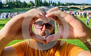 Man bearded in front of crowd people show heart gesture riverside background. I love summer holiday festival. Cheerful