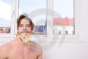 Man bearded handsome eat pizza. courier delivers gastronomic satisfaction. Guy naked holds slice of delicious pizza