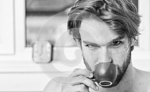 Man bearded handsome macho hold cup of coffee. Guy attractive appearance man enjoy hot fresh brewed coffee. First thing