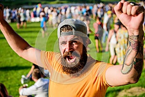 Man bearded hipster in front of crowd. Open air concert. Fan zone. Music festival. Entertainment concept. Visit summer