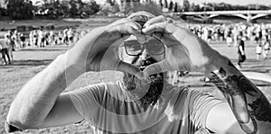 Man bearded hipster in front of crowd people show heart gesture riverside background. Hipster happy celebrate event