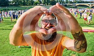 Man bearded hipster in front of crowd people show heart gesture riverside background. Hipster happy celebrate event