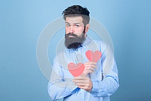 Man bearded hipster with heart valentine card. Celebrate love. Guy attractive with beard and mustache in romantic mood