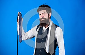 Man bearded hipster hold few neckties on blue background. Guy with beard choosing necktie. Perfect necktie. For formal