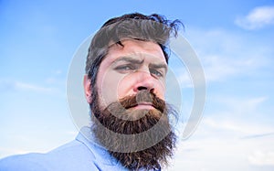 Man bearded hipster with mustache blue sky background. Expert tips for growing and maintaining mustache. Hipster serious