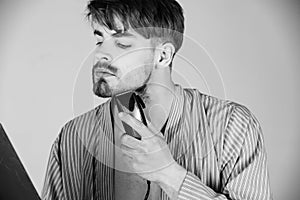 Man in blue robe shaving beard with shaver