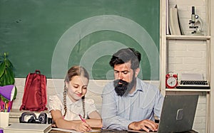 Man bearded pedagogue teaching informatics. Study online. Private lesson. School teacher and schoolgirl with laptop