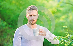 Man bearded tea farmer hold mug nature background. Green tea contains bioactive compounds that improve health. Whole photo