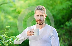 Man bearded tea farmer hold mug nature background. Green tea contains bioactive compounds that improve health. Whole photo