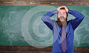 Man bearded teacher or educator hold head chalkboard background. Pay attention to your behaviour and manners. Teacher
