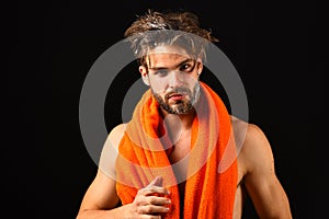 Man bearded tousled hair covered with foam or soap suds. Wash off foam carefully. Man with orange towel on neck ready to