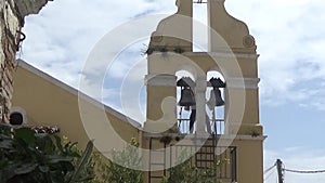 A man beats the bells on the bell tower with two hands. The end of church service.