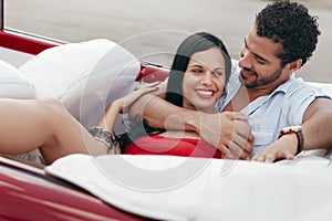 Man and beautiful woman hugging in cabriolet car